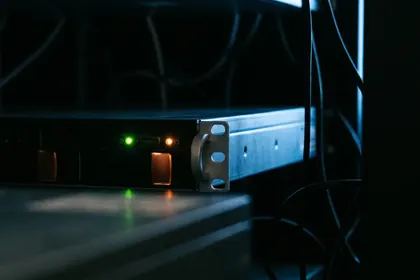 Un solo servidor encendido en un cuarto de equipos a oscuras